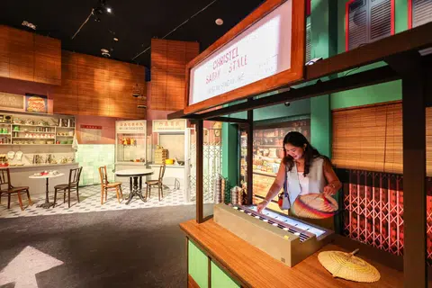 Visitors can enjoy an interactive experience simulating the work of a satay stallholder at the SingaPop! 60 Years of Singapore Pop Culture exhibition, held at the ArtScience Museum.