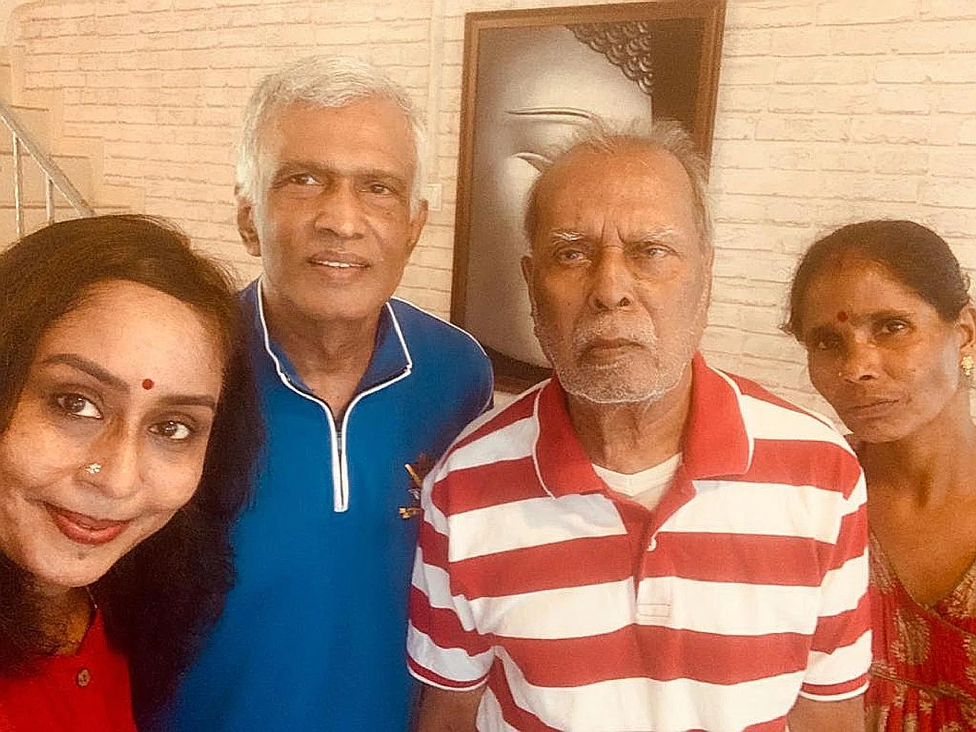 Madam Suganthi Kesavan (left) with her husband, father and helper.