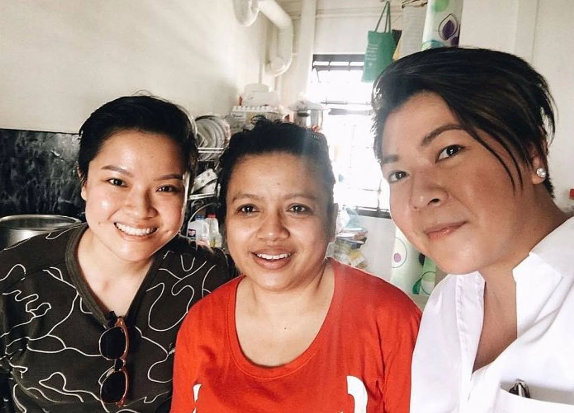 HELPING HAND: Ms Karen Chan (in white) visited Madam Jurina in July to give her the vouchers. Also in the picture is Ms Chan's friend.