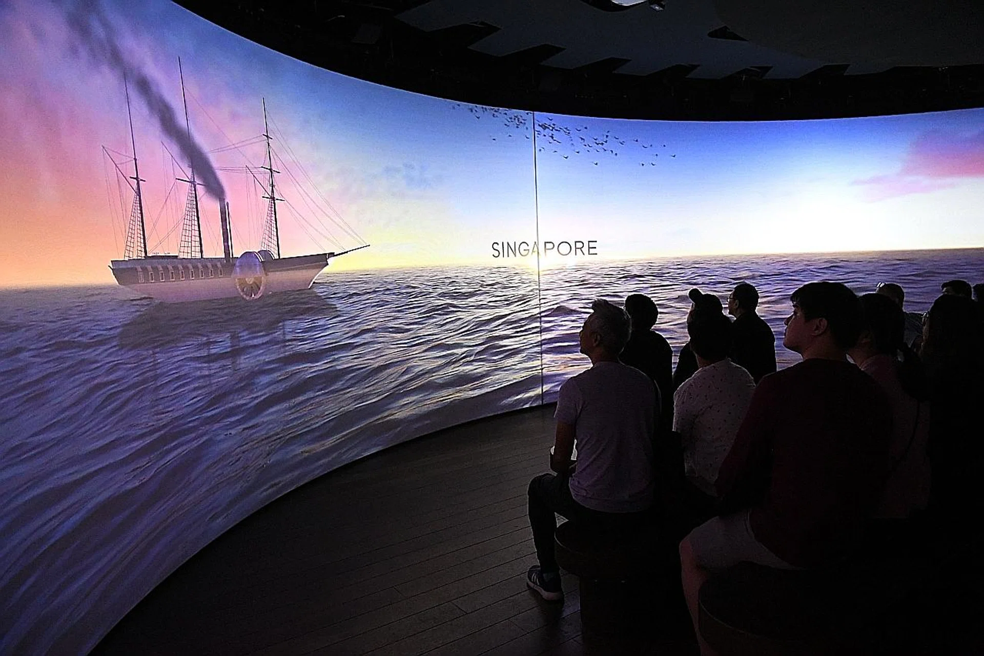 Visitors watching Act 2: Arrival, which illustrates the arrival of the British in Singapore in 1819. 