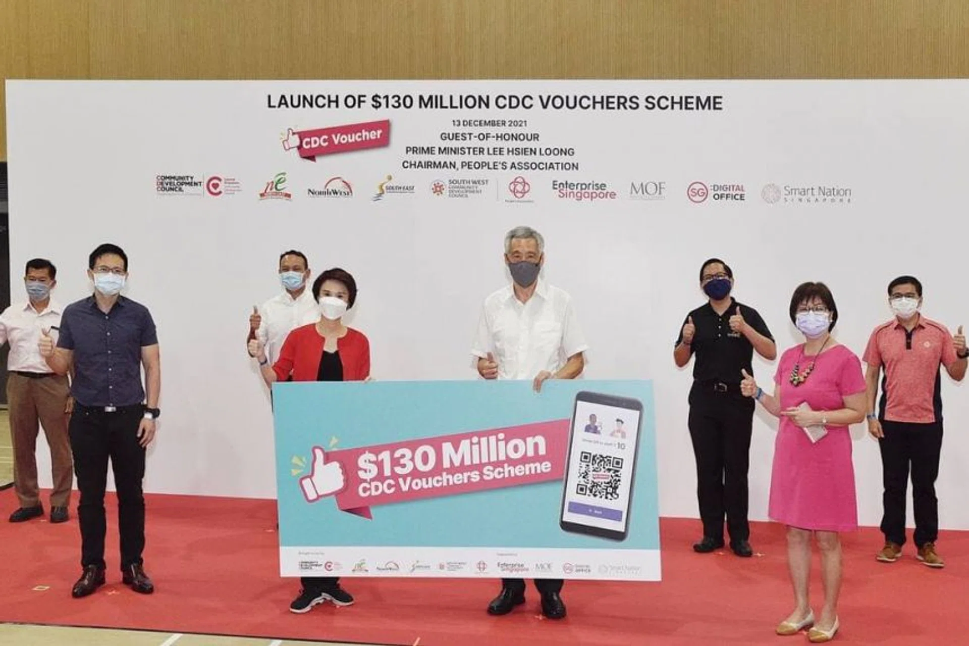 Prime Minister Lee Hsien Loong, Federation of Merchants' Associations, Singapore president Yeo Hiang Meng (left), People's Association chief executive director Lim Hock Yu (right) and the five district mayors at the launch of the third tranche of the voucher scheme.