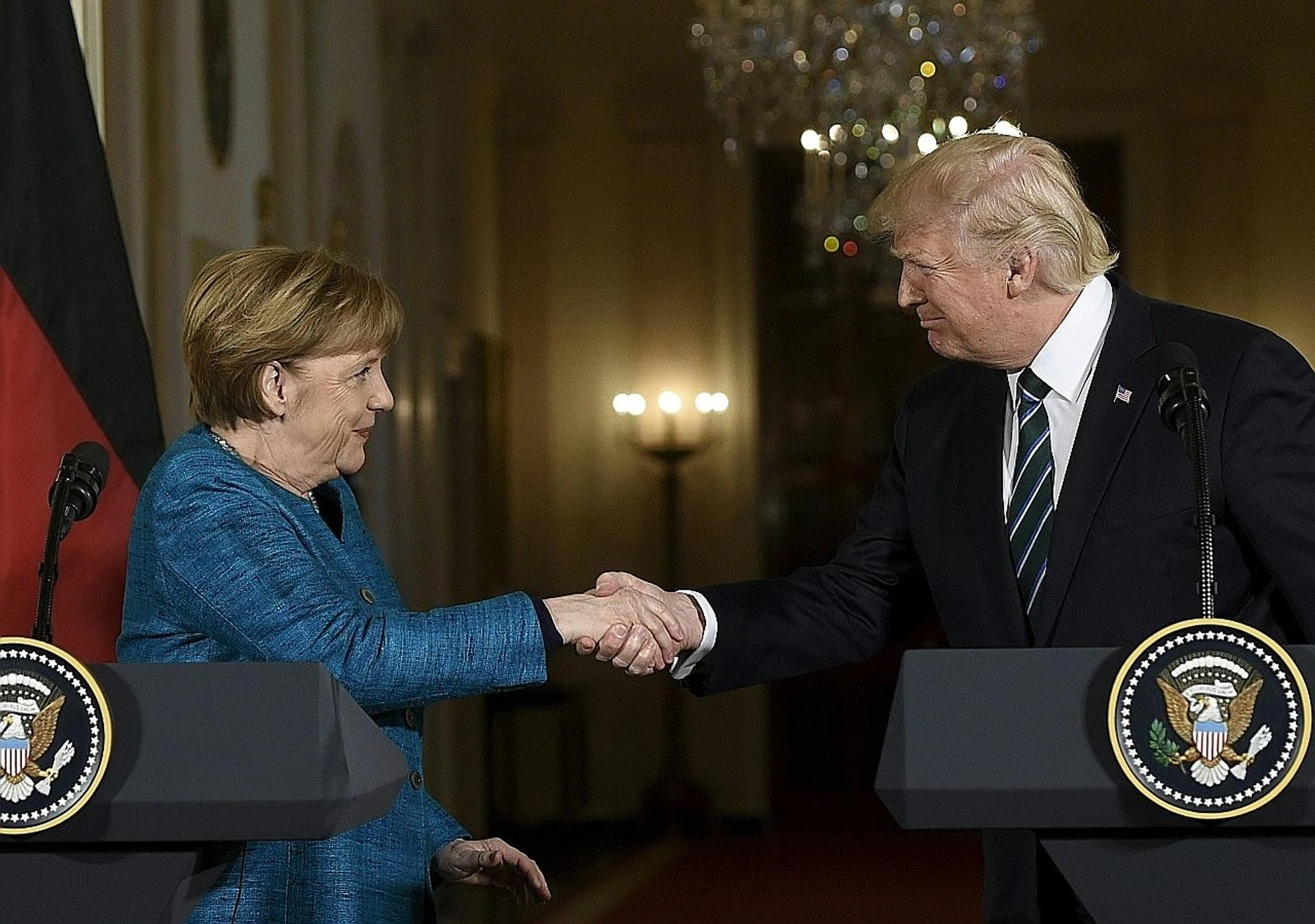 US President Donald Trump and Germany's Chancellor Angela Merkel shake hands after a press conference in the East Room of the White House on Friday. 