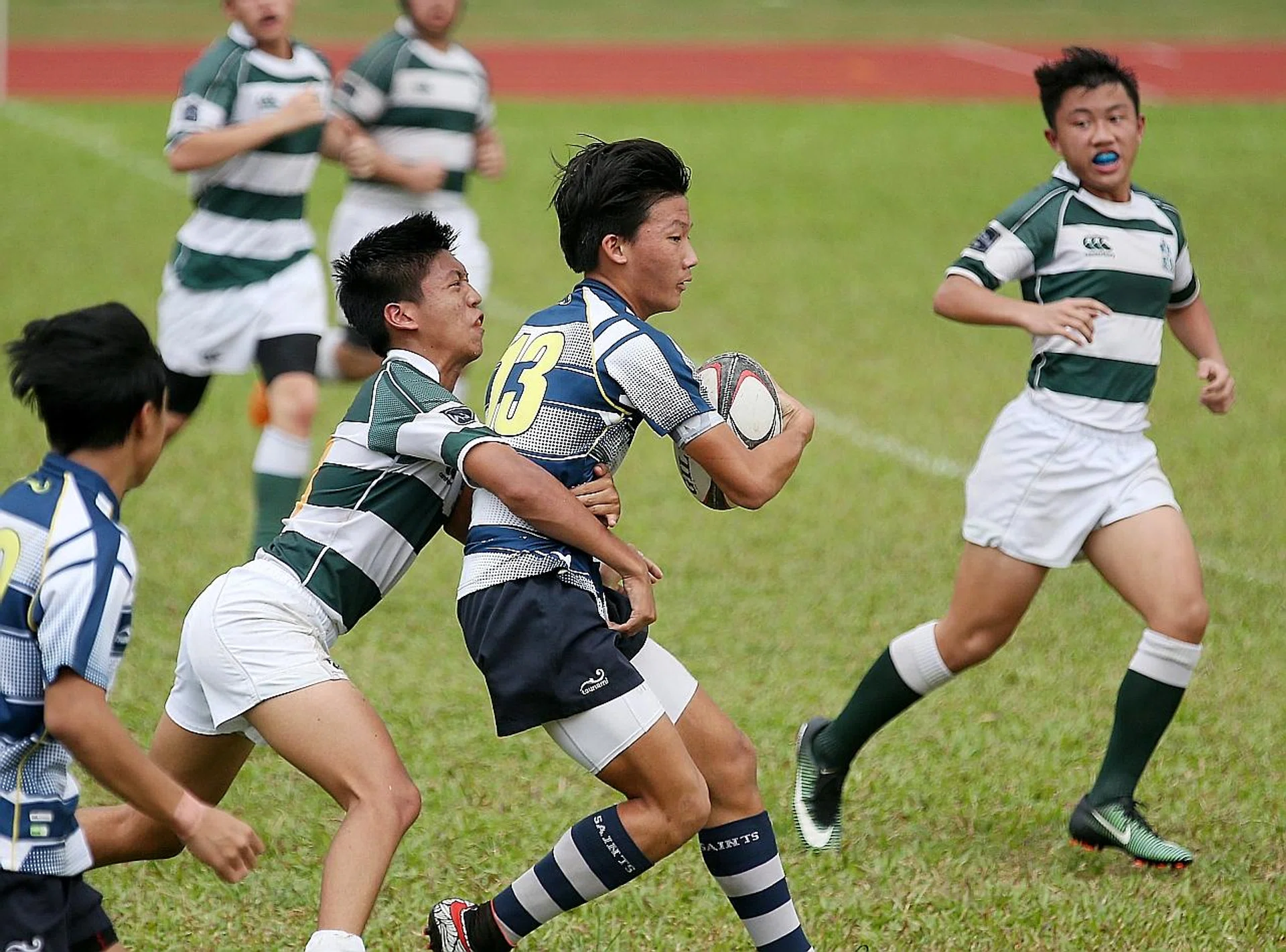St Joseph's Institution (in green and white) have no answer to the prowess of St Andrew's in the latter's 55-0 win. 