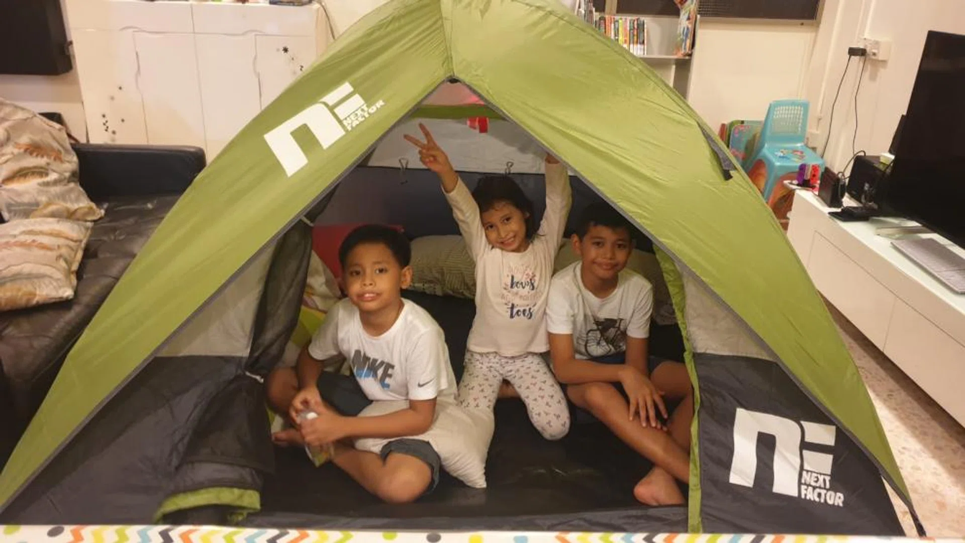 L-R: Mdm Siti Alina Talib's 3 children, Hadi, 8, Hannah, 6, and Haikel, 11, in their fully set-up tent at home. They are one of more than 60 families who took part in Camp-V.