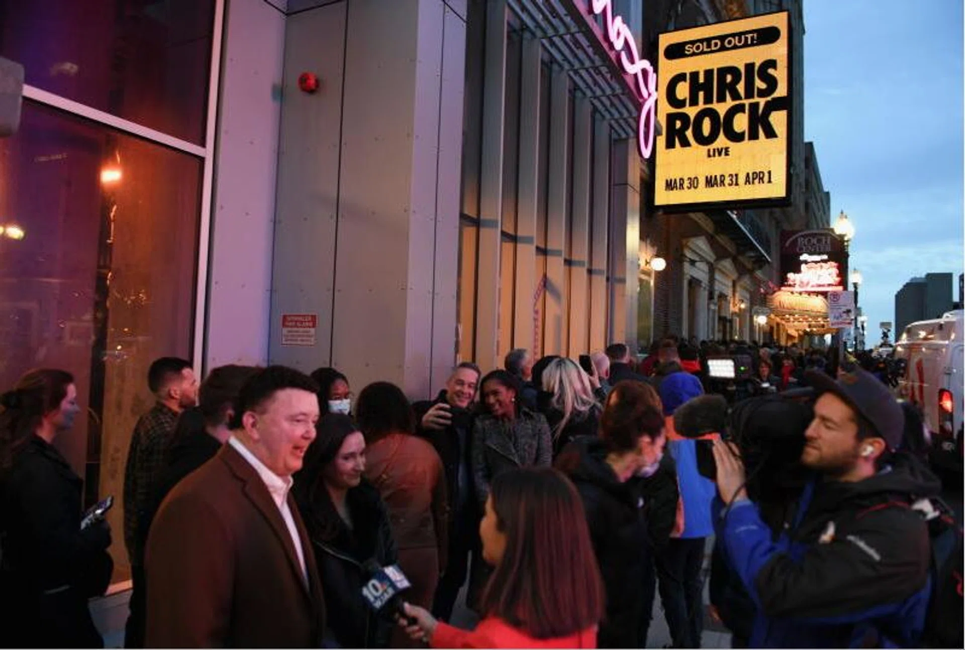 Fans being interviewed by the media as they wait outside the Wilbur Theater in Boston on March 30, 2022, ahead of a performance by actor and comedian Chris Rock, his first since being hit by Will Smith at the Oscars.