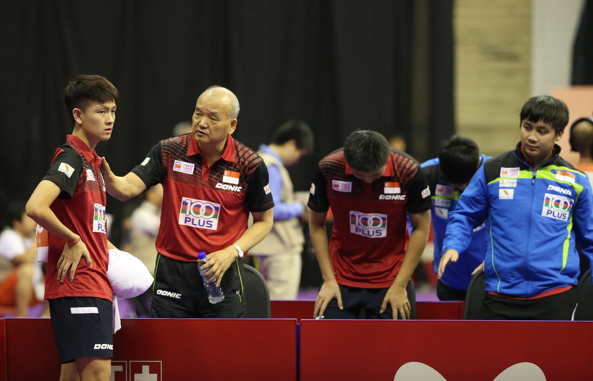 OUT: Men’s national coach Liu Jiayi (second from far left), talks to Clarence Chew during Singapore’s 3-1 defeat by Ukraine in the team’s final Group C tie yesterday. Liu has dubbed Chew Singapore’s future No. 1 male paddler. 