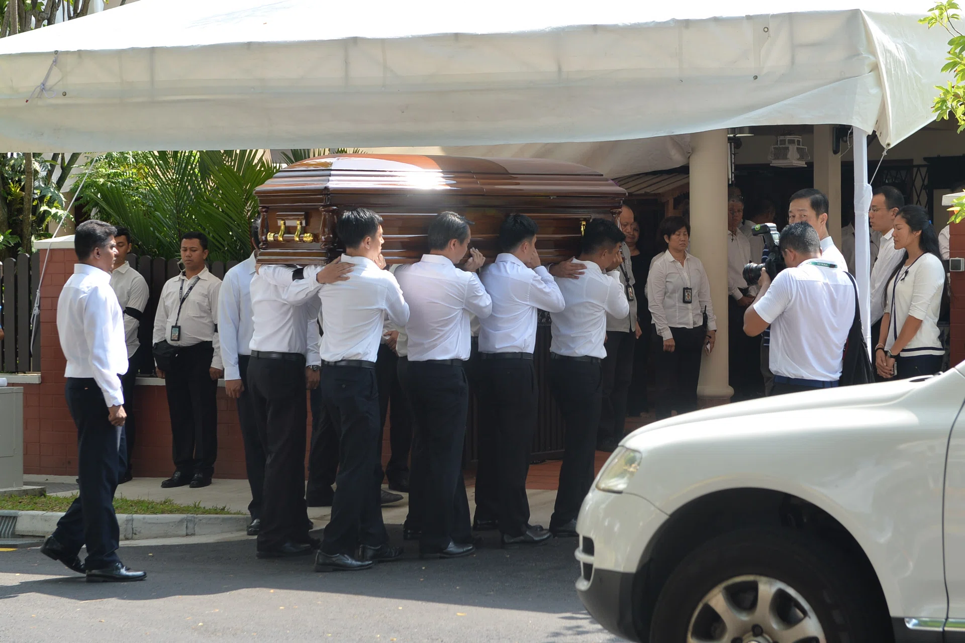PAYING RESPECTS: (Above) Pallbearers carrying Mr S R Nathan's casket into his family home. 