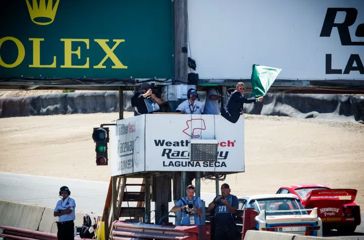Rolex Testimonee and 2022 Grand Marshal Tom Kristensen waves the green flag. (Photo: Rolex/Stephan Cooper)