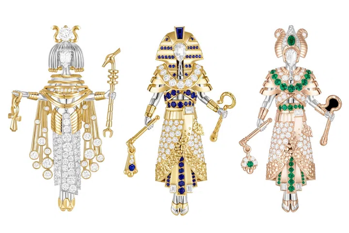Three Van Cleef & Arpels figurine clips depicting ancient Egyptian pharaohs, dressed in richly gem-set ensembles with colourful precious stones, intricate goldwork and stylised details that reinterpret Egyptian costumes in the maison’s distinctive jewellery style.
