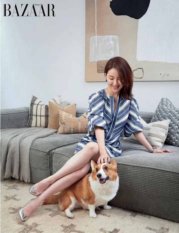 Shen, in a Kate Spade New York dress and her own Sam Edelman pumps, with Emma in the living room