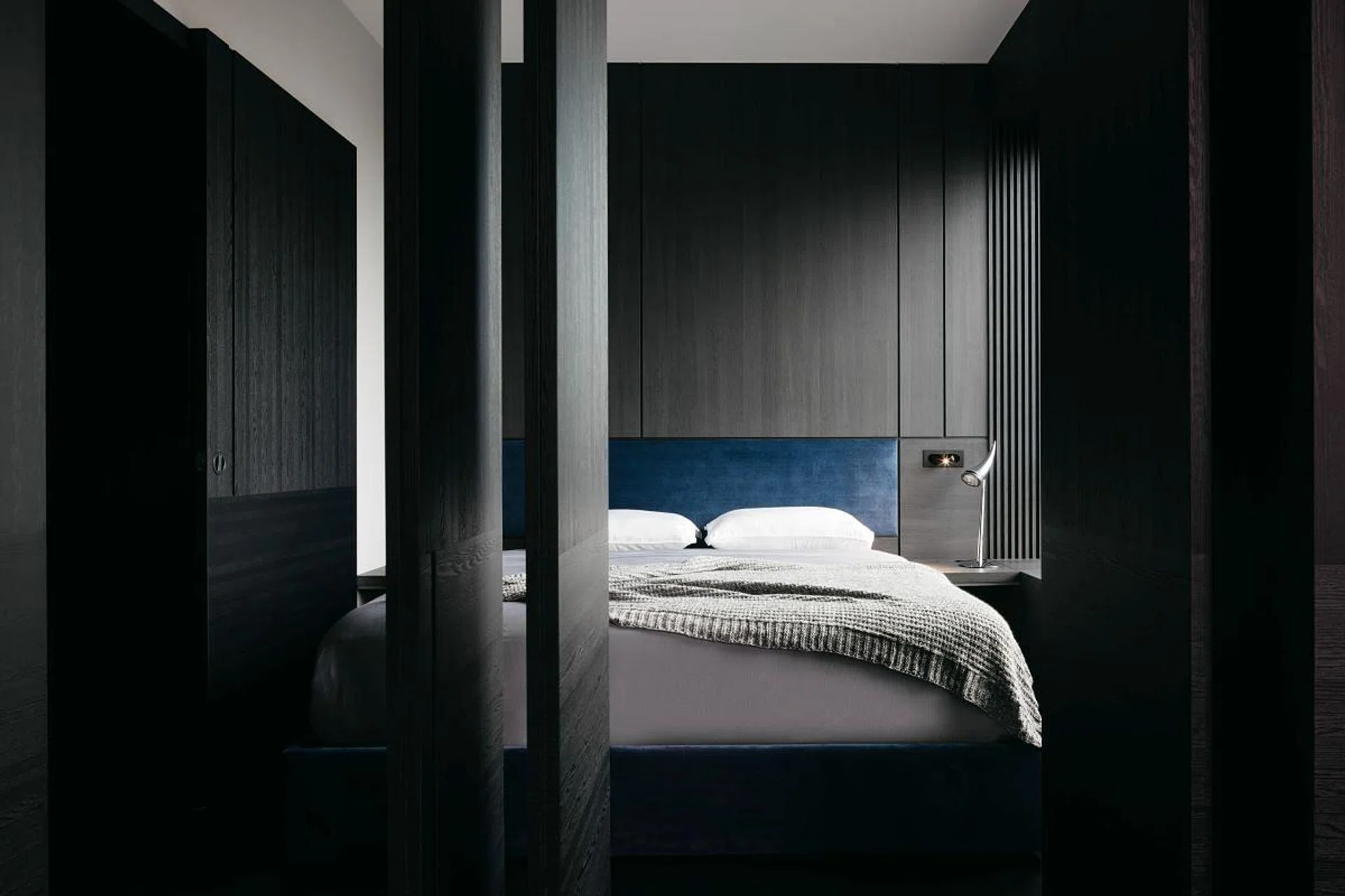 Pivot doors connect the master bedroom to a lounge area, giving homeowner Justin the option of privacy or communality. (Photo: Studio Periphery)