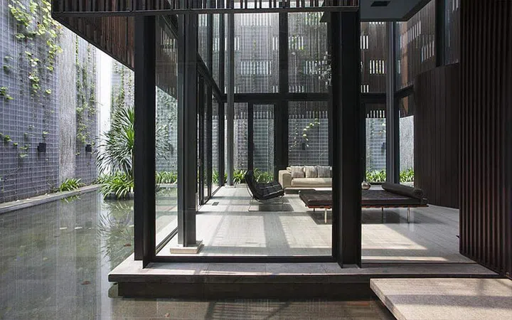 The tower surrounded by water and a green wall.