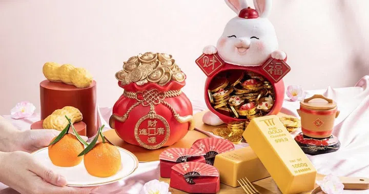 Clockwise from top left: vitality peanut cake; prosperity money pouch chocolate showpiece; longevity bunny bank chocolate showpiece; auspicious bi thang (wooden rice bucket) mini cake; fortune gold bar pound cake; lucky fan mini cake; pair of mandarins.