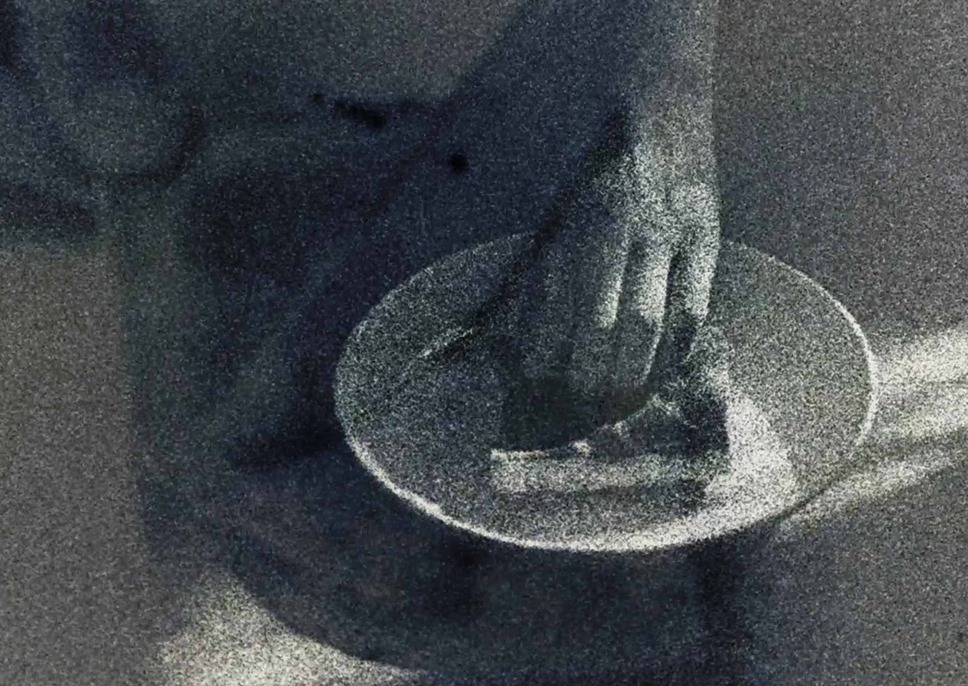 A grainy film shot of a plate of kaya toast, with a pand holding on to the bread.