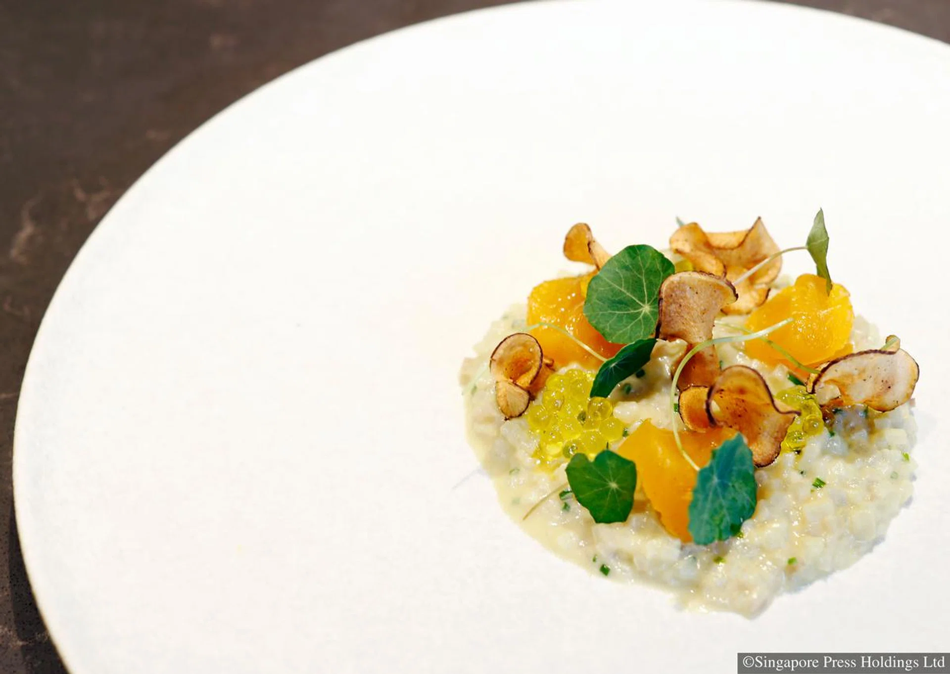 False risotto of artichoke and potato topped with confit egg yolk and artichoke chips from Tippling Club. 