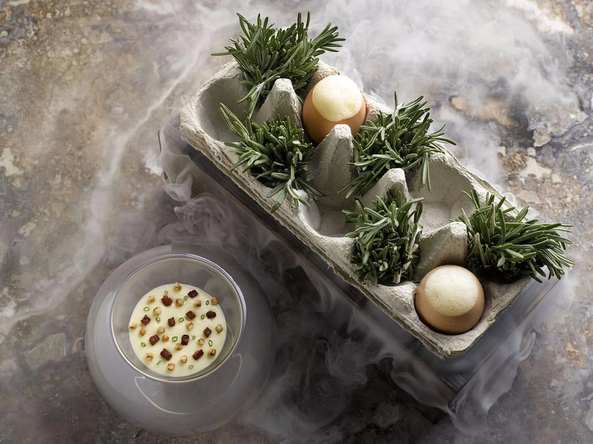 <b>Odette's famous 55 smoked organic eggs</b><br><br>
Chef-owner Julien Royer has a passion for honest cooking that makes remarkable ingredients shine, and Instagram is his tool to celebrate the various individuals behind the scenes who help to deliver the Odette experience, from farmers to the kitchen staff. While he agrees that the final look of the dish is a huge consideration, for dining is a highly visual affair, he first and foremost sticks by his philosophy of serving dishes that spotlight incredible produce. One of the most Instagrammed dishes at Odette is without a doubt his signature rosemary smoked organic egg. <br><br>“It was created back in October 2011 and was inspired by the warm comforting flavours of the classic Singaporean breakfast of soft boiled eggs. The dish features organic egg which is slow-cooked at 63.7 degrees before being infused with the lovely aromas of smoked rosemary.” The simple dish wows partly with its table-side showmanship — it arrives in a cloud of dry ice, and is then served onto a bed of smoked potato puree, toasted Japanese buckwheat and iberico chorizo.