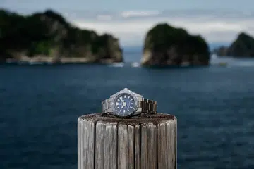 The Grand Seiko Evolution 9 Collection Spring Drive U.F.A. Ushio 300 Diver (SLGB023) in High-Intensity Titanium, featuring a 40.8mm case, deep blue gradient Ushio-pattern dial inspired by ocean tides, unidirectional ceramic bezel, luminous faceted indexes and hands, and matching titanium bracelet.