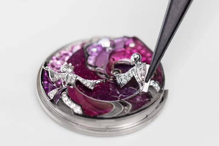 Artisan crafting the Van Cleef & Arpels Lady Retrouvailles Céleste Extraordinary Dial, showcasing the meticulous application of enamel and precious materials used to depict the celestial love story of Niulang and Zhinu with exceptional métiers d’art craftsmanship.