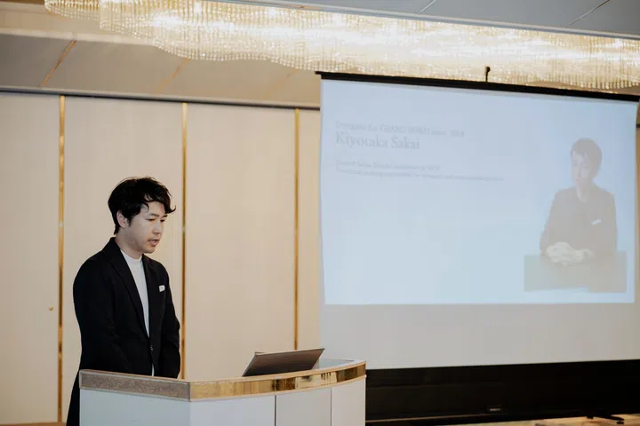 Grand Seiko product designer Kiyotaka Sakai delivering a presentation in a ballroom at a traditional ryokan in Dogashima, Nishi-Izu, explaining the design inspiration, Evolution 9 philosophy and Ushio dial concept behind the Spring Drive U.F.A. Ushio 300 Diver to invited media.
