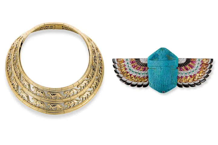 Two Cartier creations inspired by ancient Egypt: the 1991 Panthère-pattern broad collar necklace with concentric rows of stylised panther motifs, and the 1925 Cartier London Scarab brooch, depicting a winged scarab set with colourful gemstones in the geometric Art Deco style.