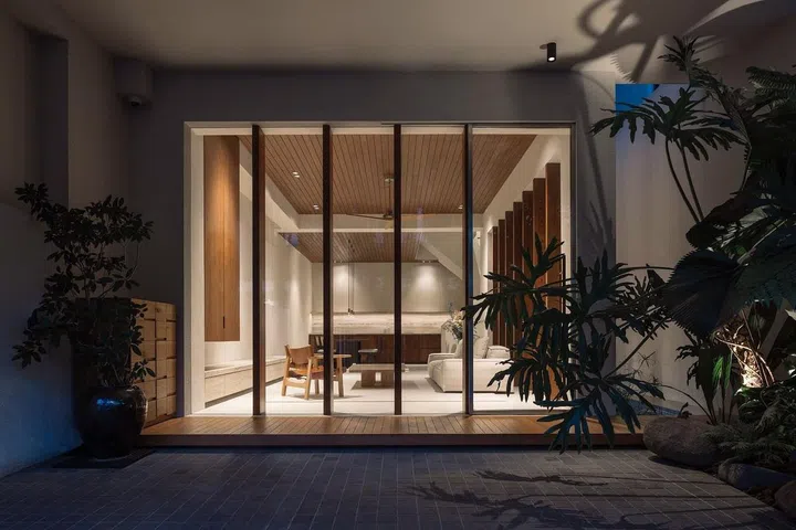Living, dining, and dry kitchen function as a single space on the ground level, conceived like a pavilion in a resort. (Photo: Studio Periphery)