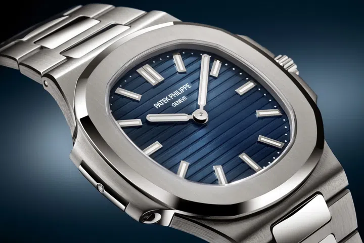 Patek Philippe Nautilus 50th anniversary Ref. 5610/1P-001 in platinum, featuring a 38mm case, blue sunburst dial with horizontal relief embossing, luminescent white gold hour markers and hands, and integrated platinum bracelet.