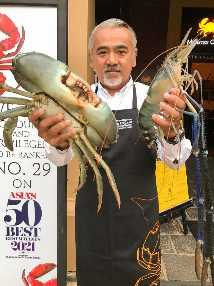 Chef Munidasa holding a mud crab and giant freshwater prawn (Photo: Ministry of Crab)
