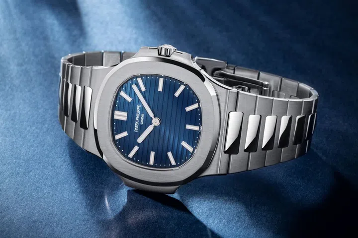 Patek Philippe Nautilus 50th anniversary Ref. 5810/1G-001 in white gold, featuring a blue sunburst dial with horizontal relief embossing, luminescent baton hour markers and integrated white gold bracelet.