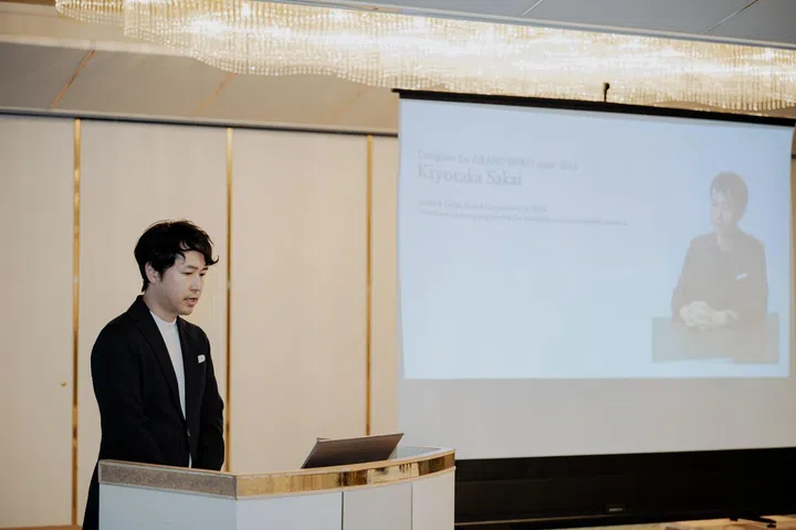 Grand Seiko product designer Kiyotaka Sakai delivering a presentation in a ballroom at a traditional ryokan in Dogashima, Nishi-Izu, explaining the design inspiration, Evolution 9 philosophy and Ushio dial concept behind the Spring Drive U.F.A. Ushio 300 Diver to invited media.