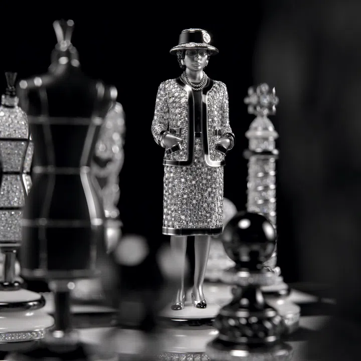Diamond-set figurine of Gabrielle Chanel as a chess queen, dressed in a tweed-inspired suit with black and white ceramic details.