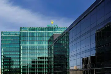 Exterior view of Rolex’s world headquarters in Geneva, Switzerland, featuring the modern office complex and the brand’s iconic crown logo.