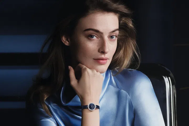Van Cleef & Arpels Perlée watch in white gold featuring a 23mm case framed by the collection’s signature golden beads, a deep-blue aventurine glass dial with a radiating guilloché pattern, and brilliant-cut diamonds adorning the bezel and inner flange.