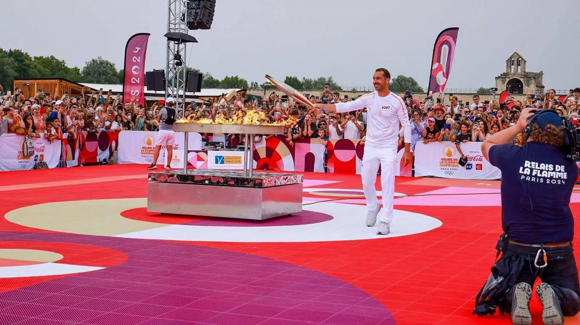 Former handball athlete, Michael Guigou, lighting the Olympic torch. (Photo: Paris2024)