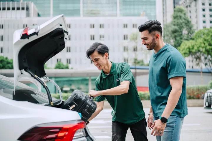 grab driver putting passenger luggage in car, private airport transfer singapore