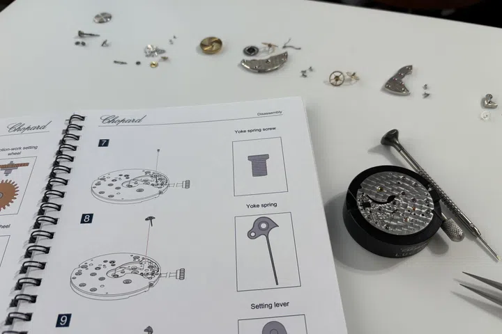 An illustrated Chopard training guide is opened beside the L.U.C Calibre 63.03-C training movement during the masterclass, providing participants with detailed diagrams of the movement’s components, architecture and the sequence for disassembly and reassembly.