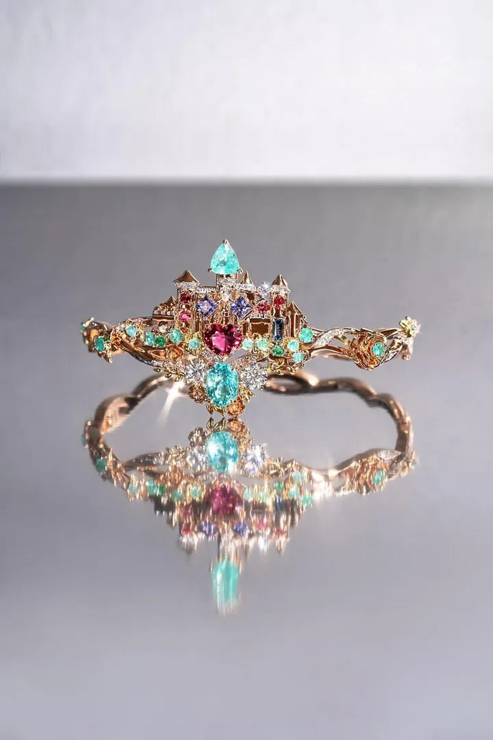 A fairytale-themed bangle with a detachable castle, adorned with spinels, Paraiba tourmalines, emeralds, tanzanites, aquamarines, and diamonds. (Photo: Madly Gems)