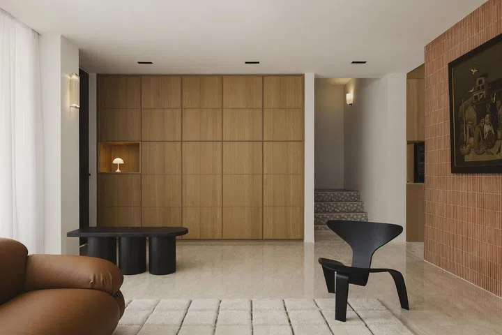 The terracotta wall becomes an anchor in the first-storey open plan and the surface for the couple’s artworks. (Photo: Studio Periphery)