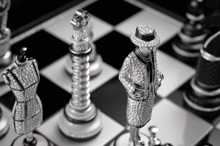 Detail of Chanel’s Coco Game chessboard showing the queen piece modelled after Gabrielle Chanel, the rook or castle represented by the Vendôme Column, and the bishop depicted as a couture bust, crafted in white gold, ceramic, and diamonds.
