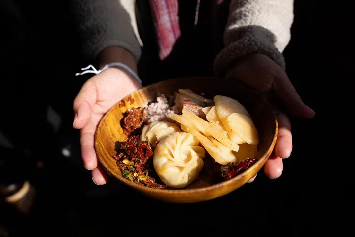 AndBeyond's guests can experience traditional Bhutanese hospitality at farmhouse visits offering iconic foods like ema datshi (chilli cheese), momo dumplings and arra, a local moonshine. (Photo: Josh van der Ploeg)