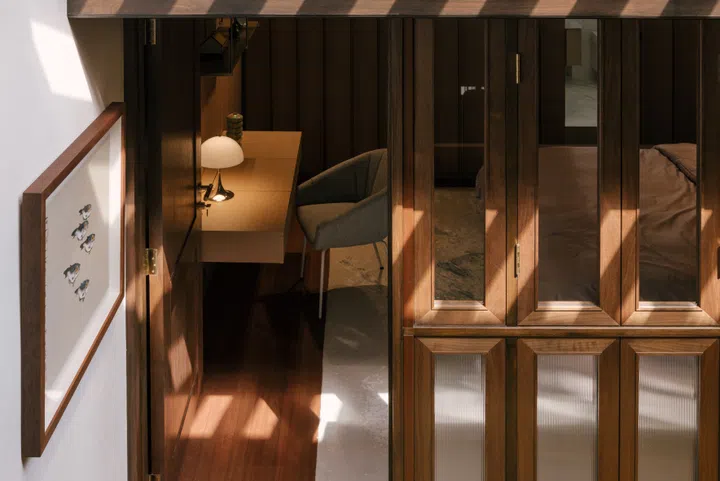 New timber frame windows in the daughter’s bedroom, inspired by the shophouse’s traditional fenestrations. In the corridor is the artwork Together by Singaporean artist Ling Yang Chang. (Photo: Finbarr Fallon)