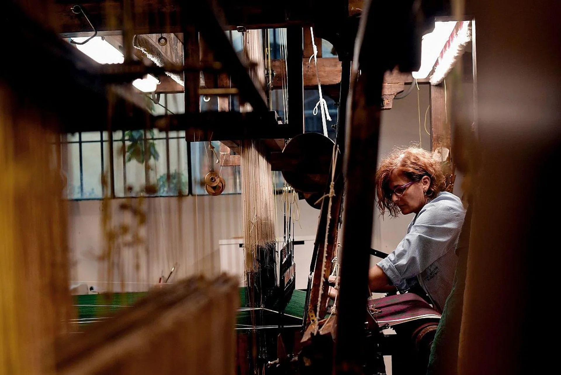 A woman at work in the laboratory of Antico setificio Fiorentino ancient silk factory in Florence