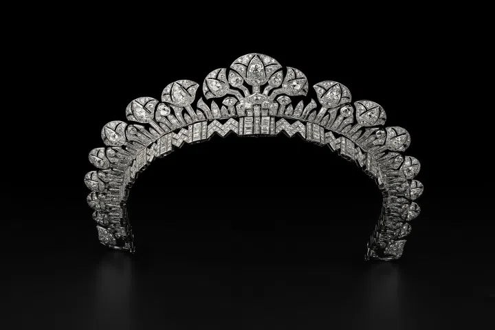 Cartier London’s Halo Tiara from 1934, featuring an openwork Art Deco design with stylised lotus flowers, papyrus leaves and radiating fan motifs, set with brilliant-cut diamonds and onyx in platinum against a dark background.