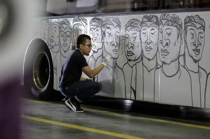 Local street artistFarizwan Fajari,who goes by thealias Speak Cryptic,paints an SBS busas part of ArtscienceMuseum’spromotion for theexhibition.