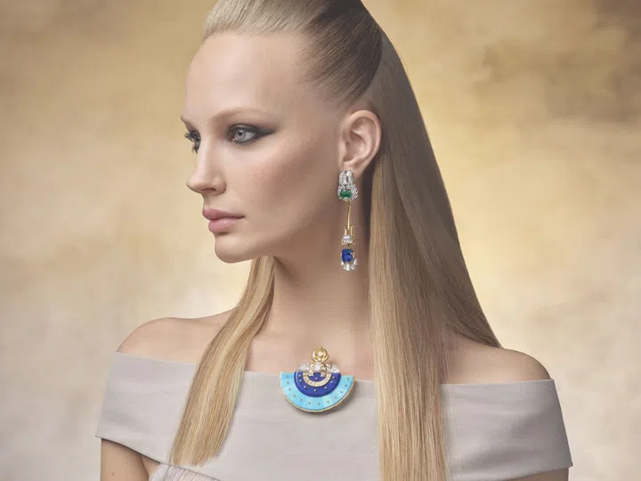 Model wearing Van Cleef & Arpels Fascinating Egypt Venus Egyptienne clip in yellow and white gold, lapis lazuli, turquoise, and diamonds; and the Elevation Precieuse earrings in yellow and white gold, blue sapphires, emeralds, and diamonds.