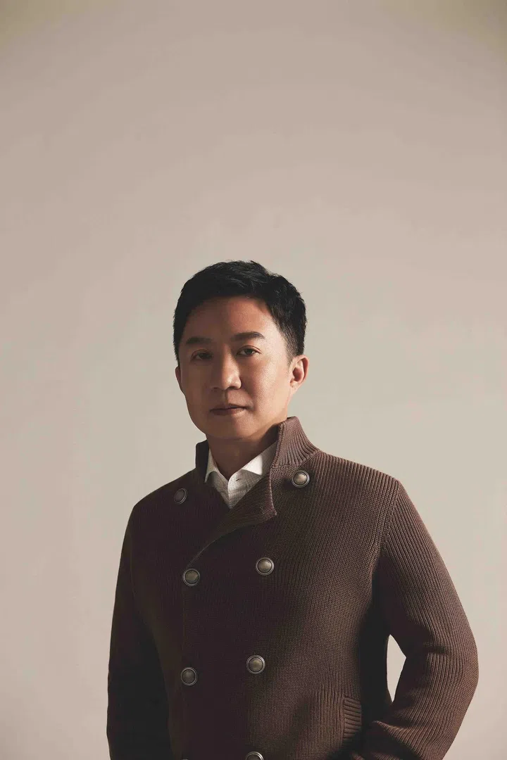 Zou is wearing a a cotton shirt and wool knit cardigan from Brunello Cucinelli.