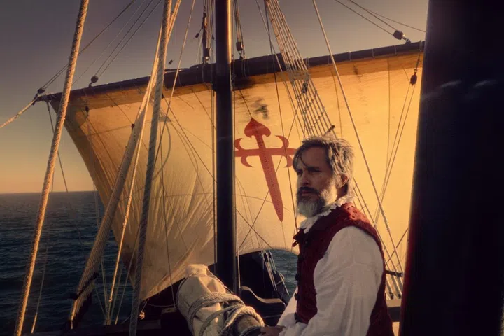 A man stands on a old sailing ship.