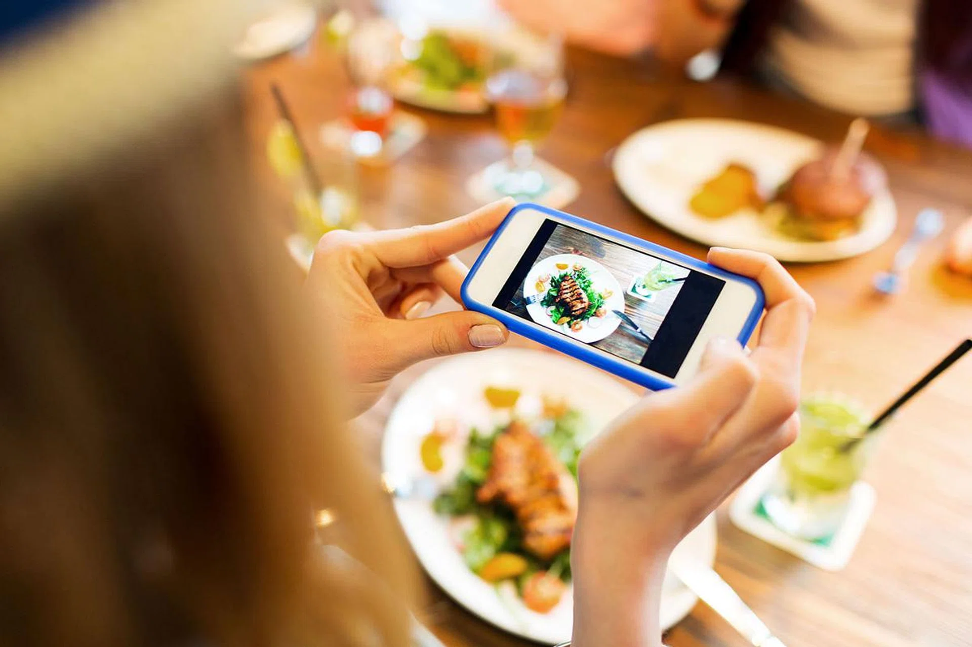 52912534 - people, leisure, technology and internet addiction concept - close up of woman with smartphone photographing food at restaurant
