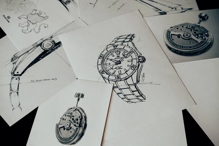 Design sketches of the Grand Seiko Spring Drive U.F.A. Ushio 300 Diver displayed beside photographs of the Calibre 9RB1 Spring Drive movement, highlighting the watch’s development process, engineering refinements and the movement that delivers an annual accuracy of ±20 seconds.