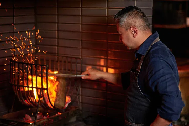 Revolver’s chef Jitin Joshi works his magic with the wood-fire grill, offering a theatrical experience for diners. (Photo: Revolver)