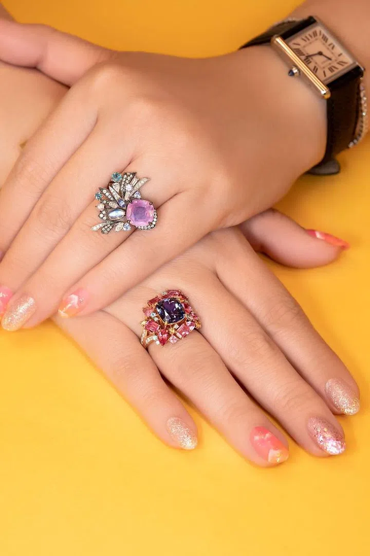 (Top) A ring set with a pink sapphire as well as diamonds, moonstone, tanzanite, and alexandrite. (Bottom) A ring set with tanzanite, hot-pink spinel, mandarin garnet, and Paraiba tourmaline. (Photo: Madly Gems)